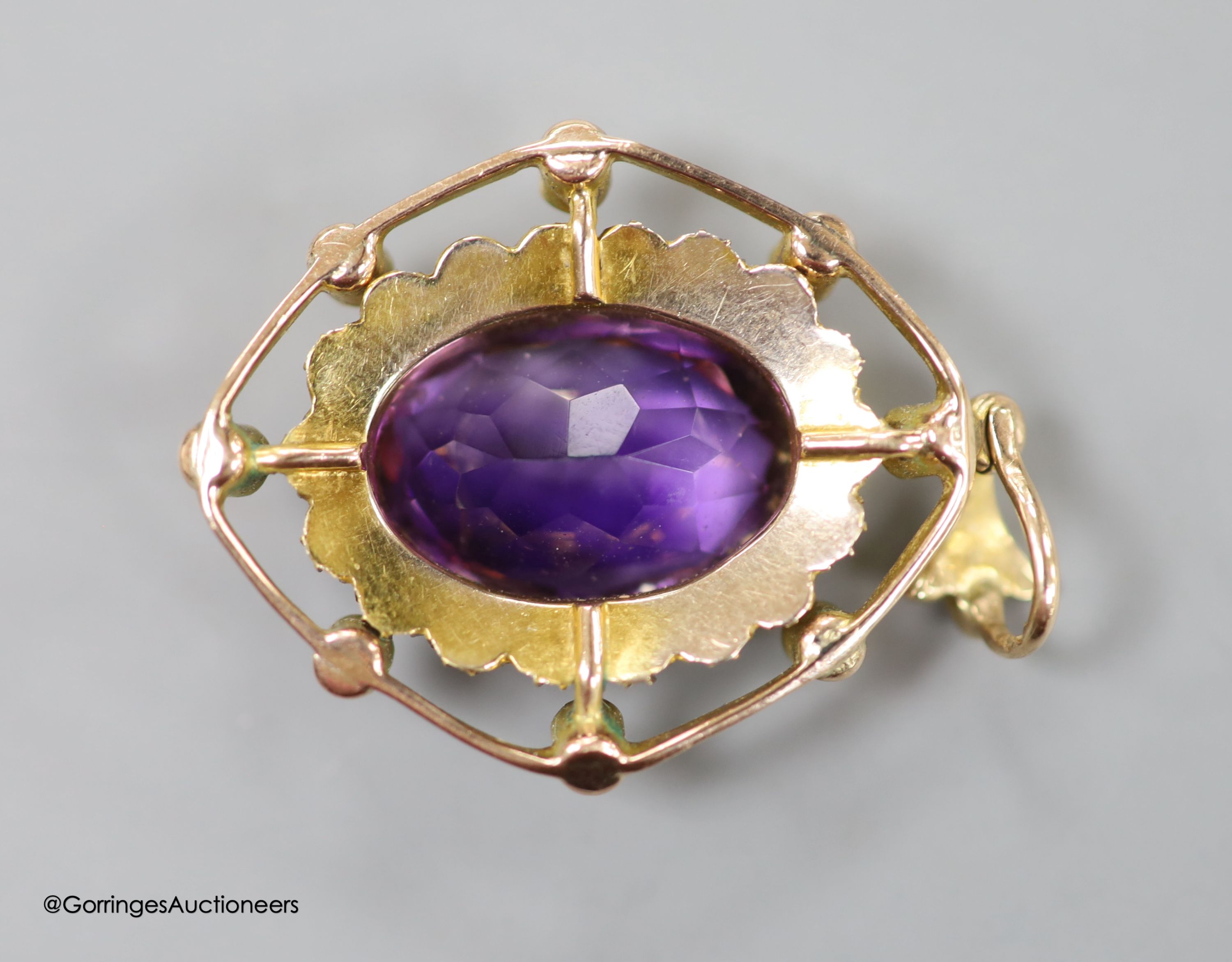 An early 20th century yellow metal, amethyst, split pearl and green stone set oval pendant, in the Suffragette colours, overall 39mm, gross weight 5.5 grams (a.f.).